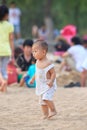 Cute Chinese toddler walks on a beach, Beijing, China